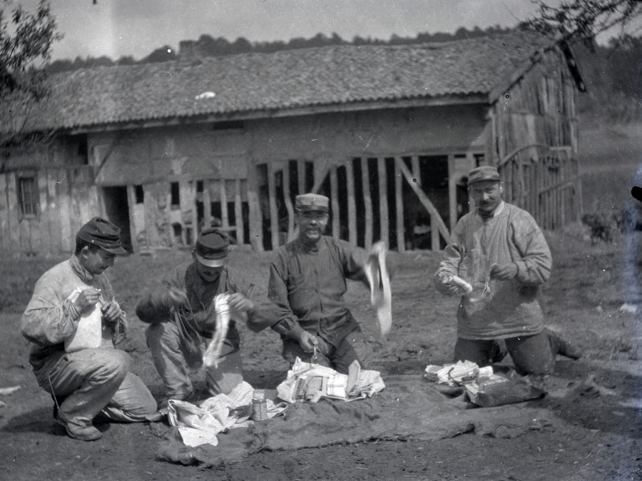 Quatre soldats sur le front recevant des colis de linge, scne quotidienne de la vie au front, priode 1914-1918
