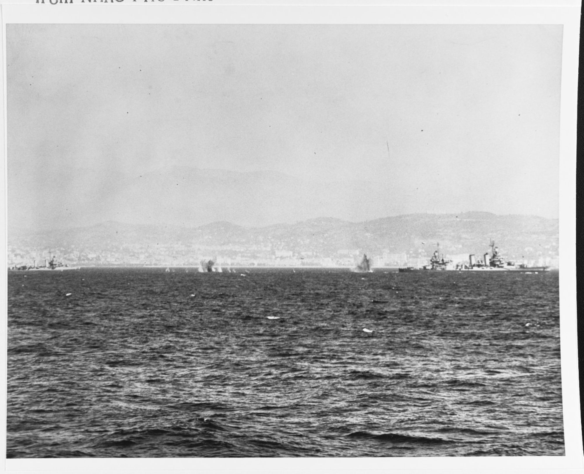 Des navires de guerre américains, l’USS Tuscaloosa à droite et un destroyer à gauche, engagent des batteries côtières allemandes au large de Cannes, 21 août 1944. Naval history and heritage command, 80-G-245615
