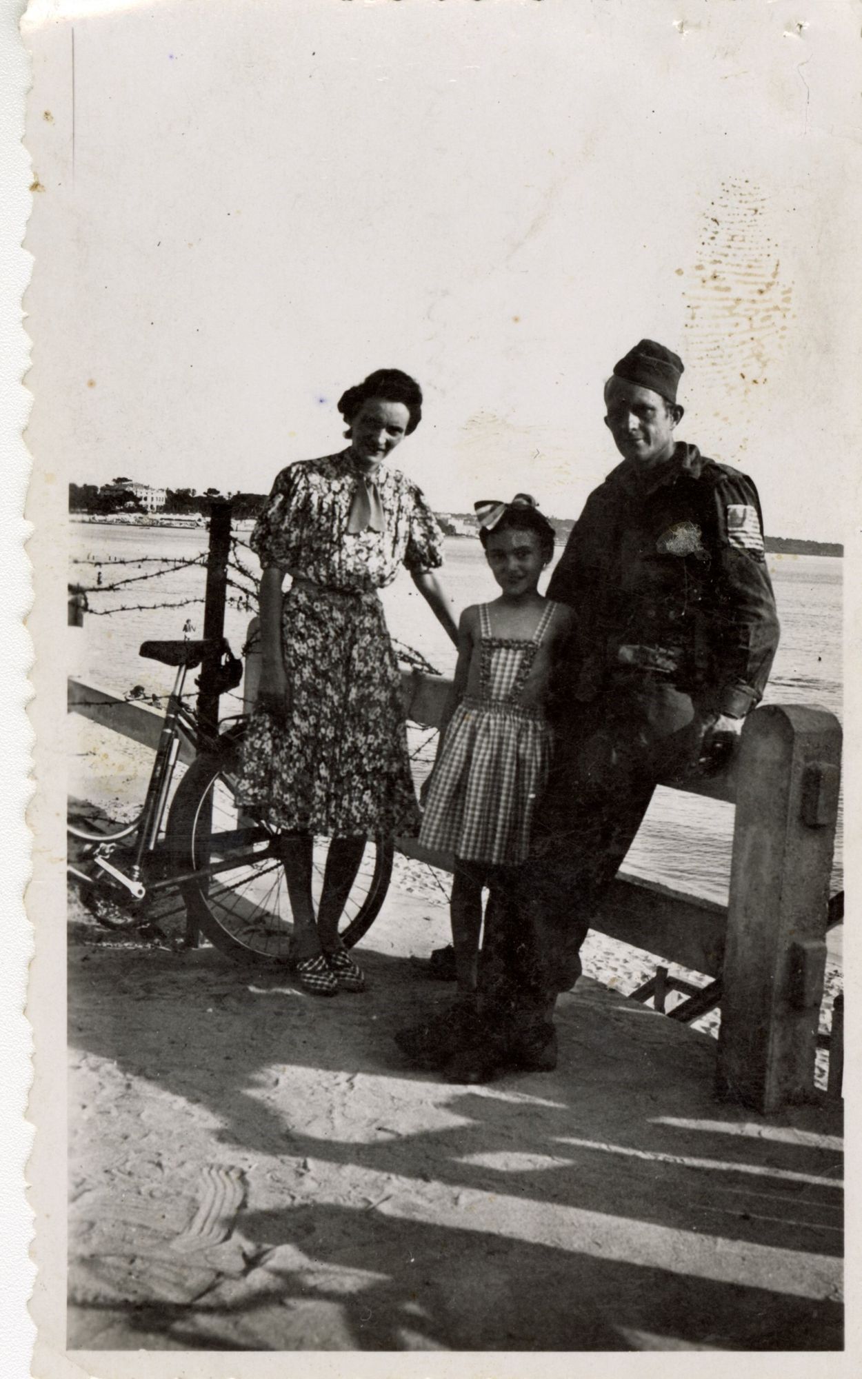 La petite Madeleine, âgée de 9 ans, et sa mère, Marie-Thérèse Maigret, se font photographier sur la Croisette aux côtés d’un parachutiste américain, 24 août 1944. Prêt famille Mazeaud. Photographie Charles Maigret