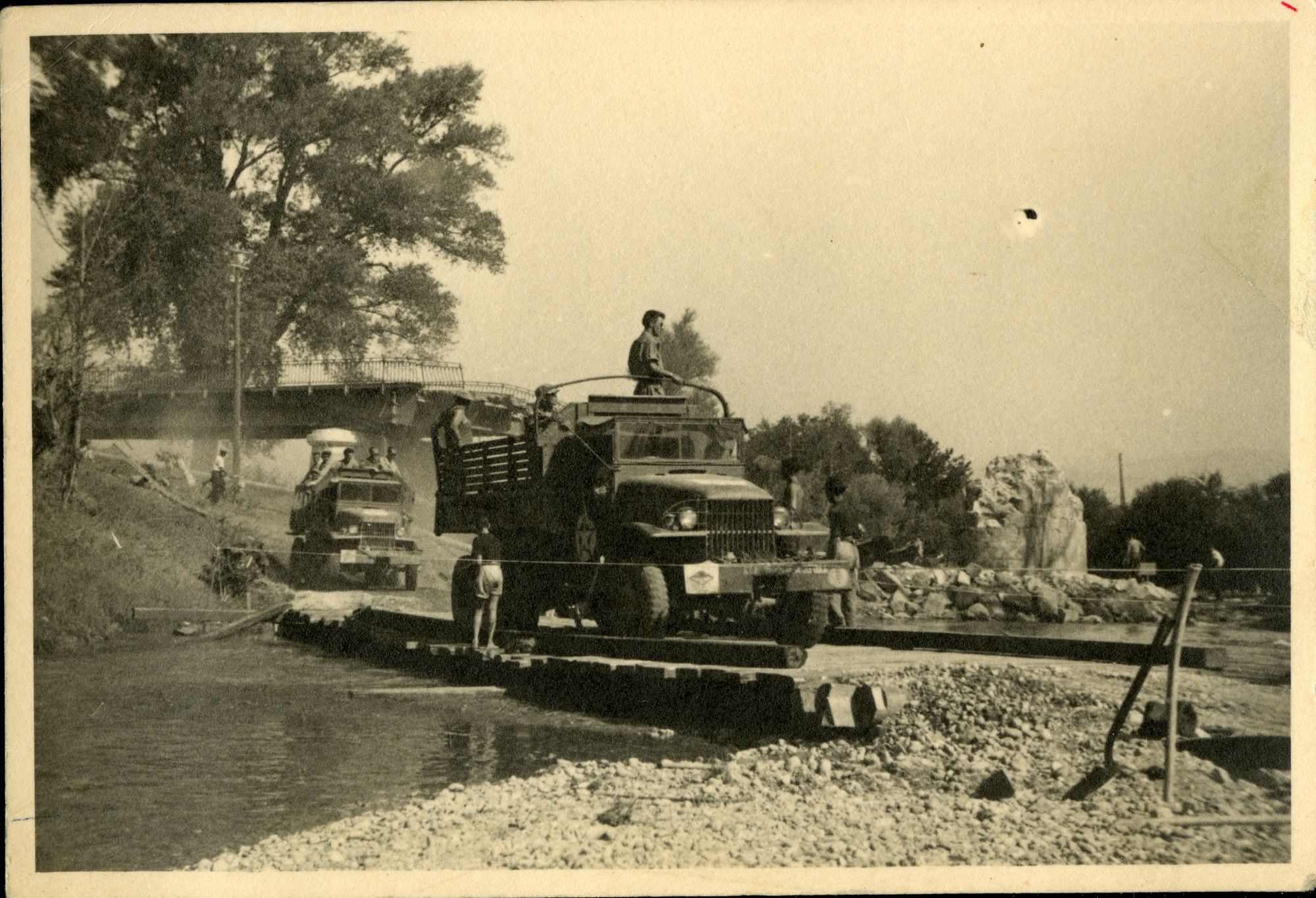 Deux camions de l’armée américaine franchissent le passage à gué sur la Siagne, construit provisoirement pour remplacer le pont détruit, non daté. Photographie anonyme. AMC, 13Fi148