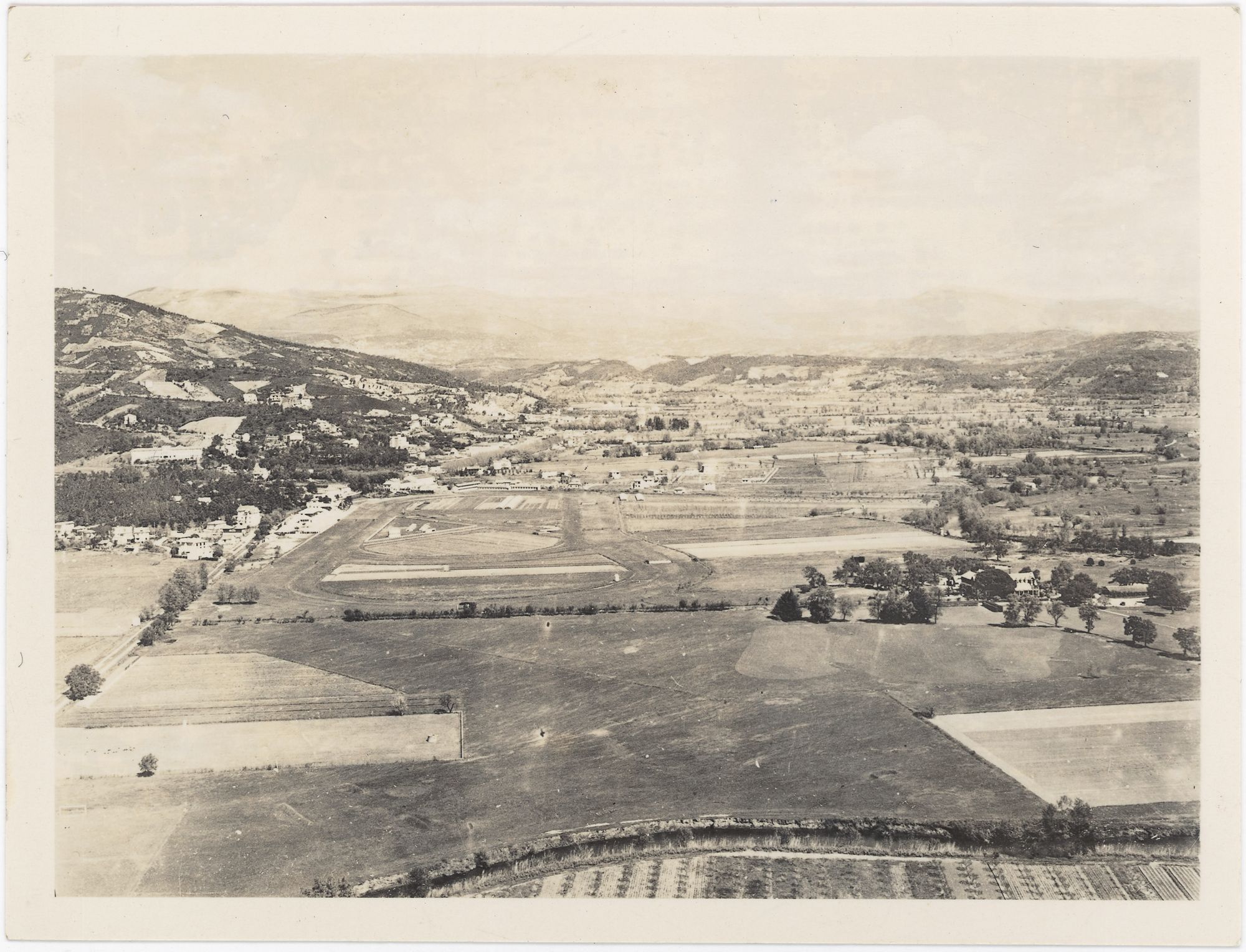 Panorama des terrains du golf et de l'hippodrome, Cannes et Mandelieu. Large vue sur les terrains avec champs cultivés et collines, vers 1920-1930. Photographie, auteur inconnu. AMC, 10Fi1503.