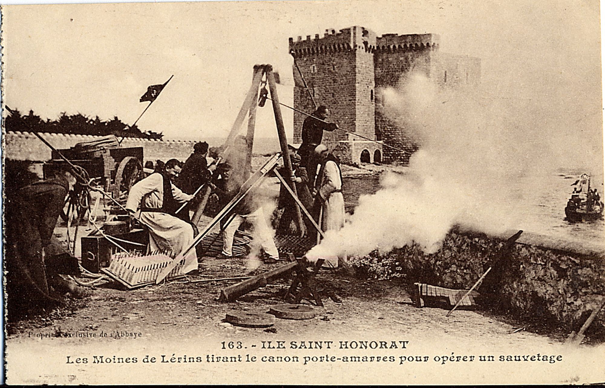 Les moines de Lérins tirant le canon porte-amarres pour opérer un sauvetage, sans date. Carte postale. AMC, 2Fi324.